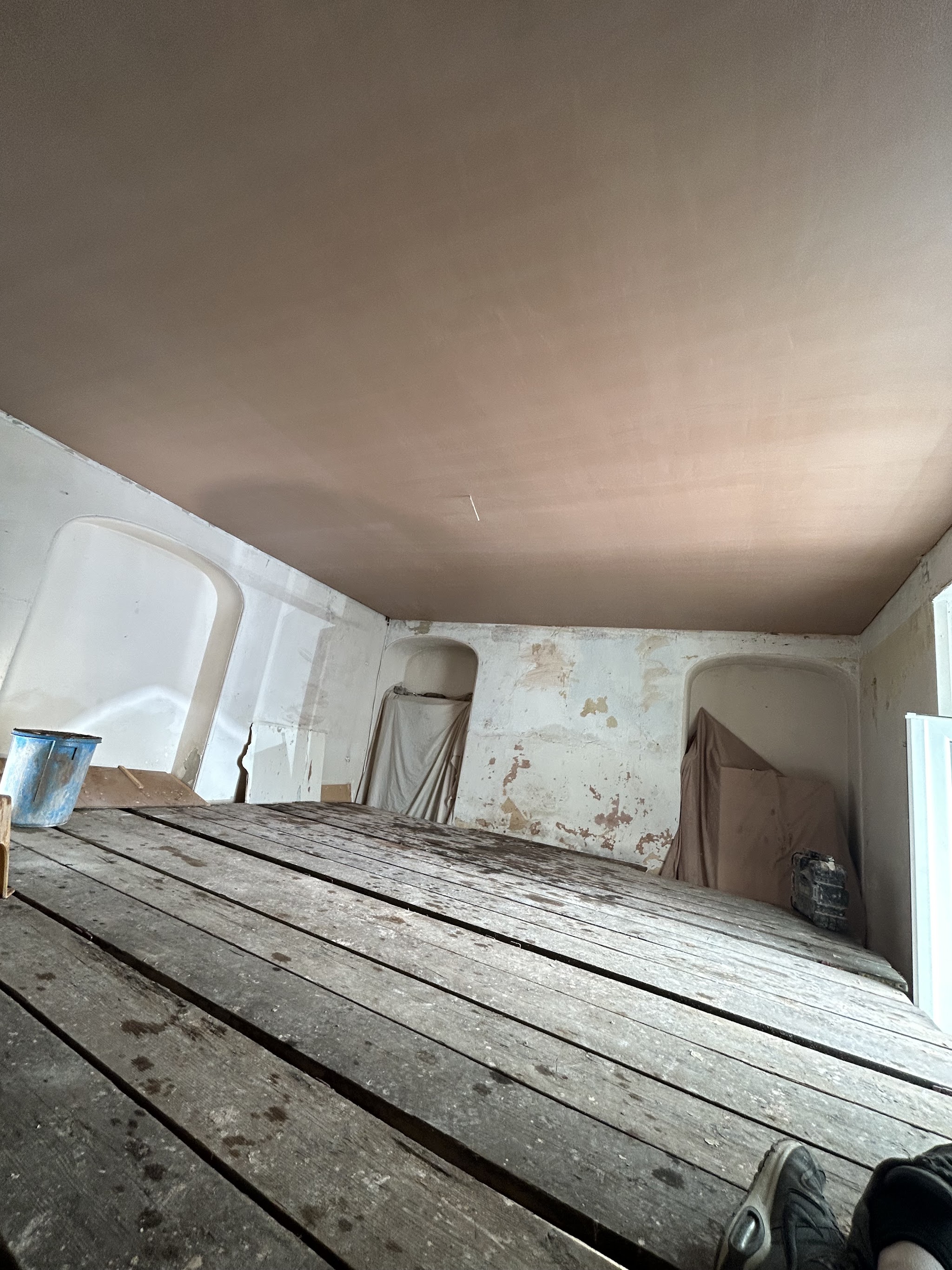 Freshly plastered ceiling above a scaffold platform in a room under renovation